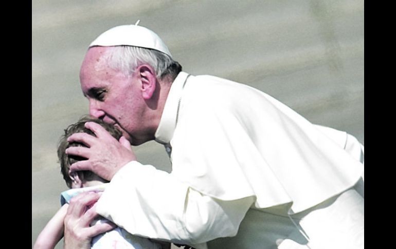 El Santo Padre besa a un niño tras concluir el Evangelio en la Plaza San Pedro. Al G-8 le pidió medidas para eliminar el hambre. AFP /