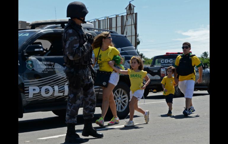 Los aficionados tienen que huir de los hechos para no resultar lastimados. AFP /