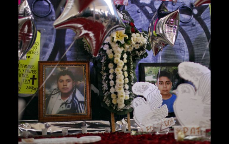 Familiares de las víctimas hacen un memorial a las afueras del News Divine. AP /