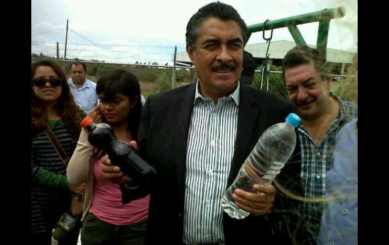 El alcalde tapatío, Ramiro Hernández muestra la diferencia entre lixiviados (jugos de basura) y agua tratada en Los Laureles.  /