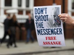 Un simpatizante de Julian Assange sostiene un letrero afuera de la embajada ecuatoriana donde se refugia. AP /