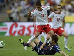 Javier Hernández lucha por la pelota ante Sakai durante el partido en Copa Confederaciones. AFP /