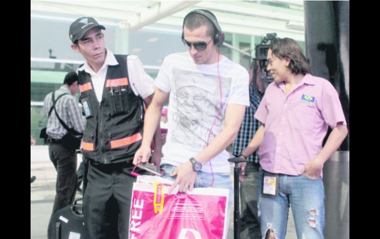 Jorge Torres Nilo aplicó la ya clásica de ponerse audífonos para escuchar música, a su llegada al aeropuerto tapatío. EL INFORMADOR /