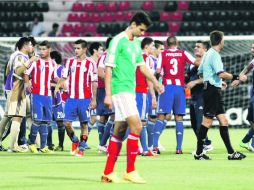 El mediocampista mexicano Raúl López luce abatido ante el triunfo del equipo paraguayo, que al fondo festeja. AFP /