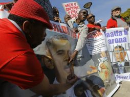 Manifestantes en Pretoria califican como 'Primer asesino del mundo' al presidente de EU. EFE /