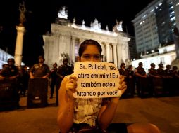 Una joven sostiene un cartel que dice: ''Señor policía, no me dispares, estoy luchando por ti'', durante una manifestación. EFE /