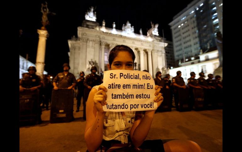 Una joven sostiene un cartel que dice: ''Señor policía, no me dispares, estoy luchando por ti'', durante una manifestación. EFE /