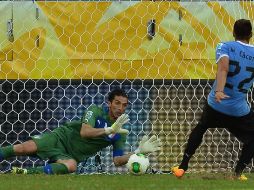 Gianluigi Buffon detiene uno de los tres penales que realizo en la serie ante Uruguay, aquí el lanzador era Cáceres. AFP /