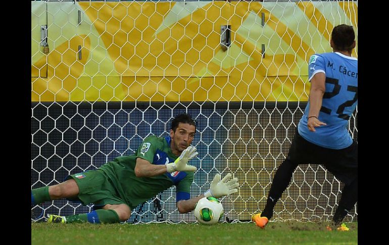 Gianluigi Buffon detiene uno de los tres penales que realizo en la serie ante Uruguay, aquí el lanzador era Cáceres. AFP /