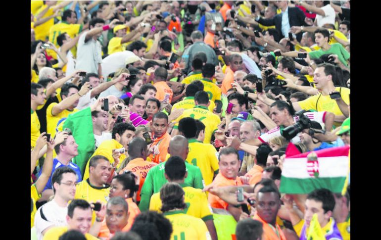 Los aficionados se abalanzaron sobre el técnico y los jugadores para felicitarlos cuando subieron a la tribuna a recoger el trofeo. EFE /