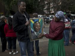 Una pareja se reune frente al hospital donde se encuentra Mandela para expresar sus deseos de que éste mejore. AP /