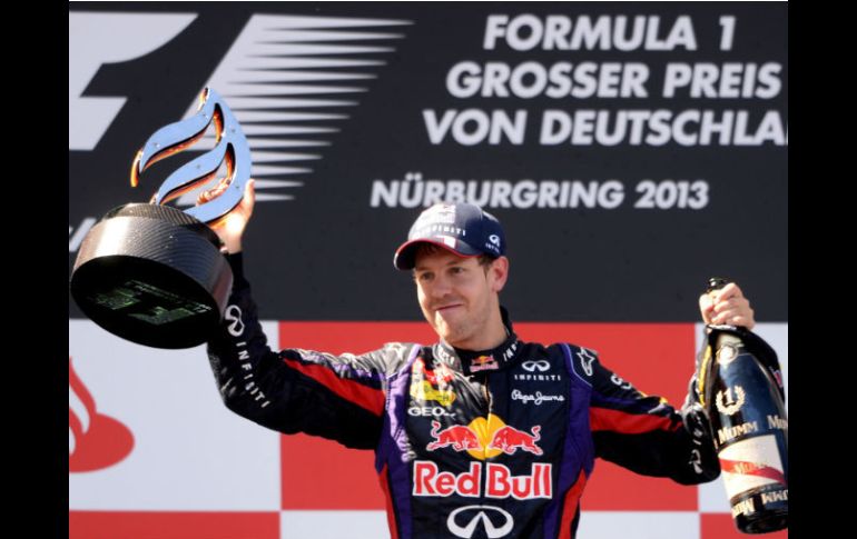 Sebastian Vettel levanta el trofeo que lo acredita como ganador del Gran Premio de Alemania. AFP /