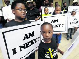 Niños muestran letreros afuera de una Iglesia en Nueva Orleans, como parte de las protestas contra el racismo. AP /