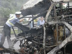 El autobús que cubría el trayecto entre Bangkok y Roi Et,  se incendió después del accidente. ARCHIVO /