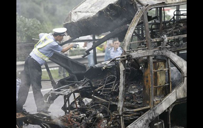 El autobús que cubría el trayecto entre Bangkok y Roi Et,  se incendió después del accidente. ARCHIVO /