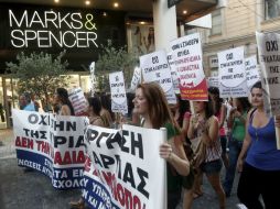 Mientras tanto, miembros del partido comunista se manifiestan en contra de la apertura de los establecimientos comerciales. ARCHIVO /