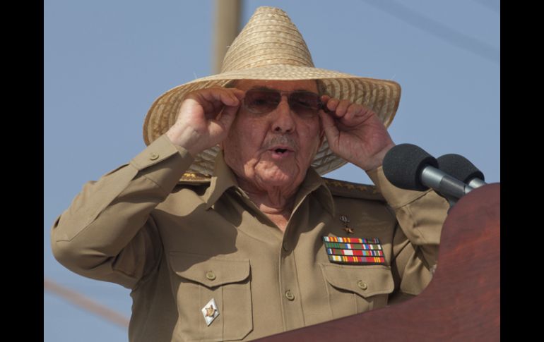 El presidente Raúl Castro, vestido con su uniforme de general, pero con un  sombrero campesino de paja para protegerse del sol. AP /