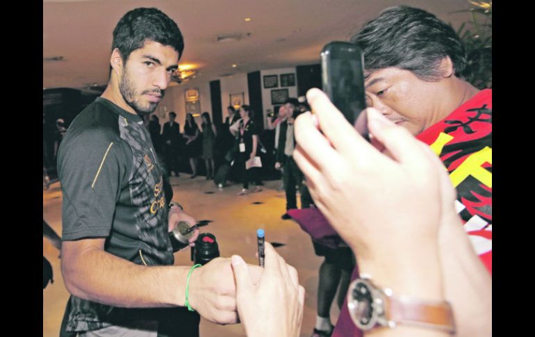 Suárez da autógrafos y se toma fotos con la afición de Bangkok. AFP /