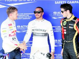 El saludo políticamente correcto entre campeones del mundo, Vettel y Hamilton, ayer los dos más rápidos, ante la mirada de Grosjean. EFE /