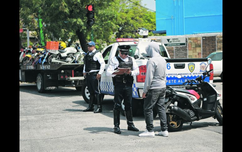 Operativo. En la Glorieta de los Niños Héroes, los policías viales pidieron sus documentos a este hombre que no llevaba casco. EL INFORMADOR /