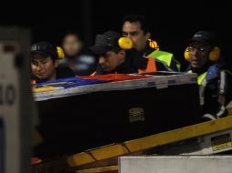 Momento en el que el ataúd de Christian Benitez es bajado del avión que lo transportaba. AFP /