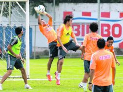 Le hace de portero. Marco Fabián salta para robarle un balón al defensa Héctor Reynoso, en la práctica de ayer. EL INFORMADOR /