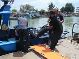 Autoridades de Malasia transportan alos restos recien encontrados en Pulau, dos mujeres y un hombre. AFP /