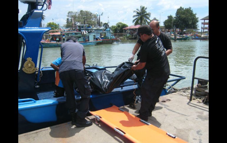 Autoridades de Malasia transportan alos restos recien encontrados en Pulau, dos mujeres y un hombre. AFP /