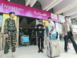 Extranjeros presentan sus documentos antes de entrar a la sala de embarque en el aeropuerto internacional de Saná para dejar Yemen. AFP /