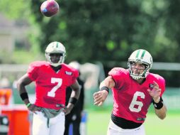 Él primero. Mark Sánchez lanza un pase ante la mirada de Geno Smith, mariscal suplente de los Jets. AP /