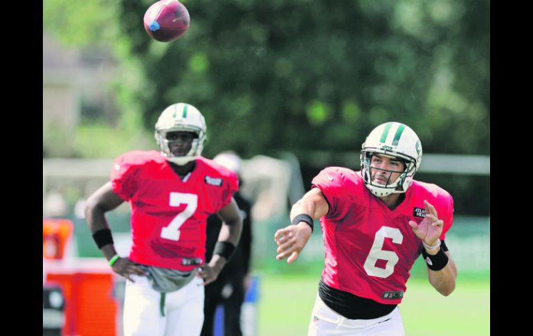 Él primero. Mark Sánchez lanza un pase ante la mirada de Geno Smith, mariscal suplente de los Jets. AP /