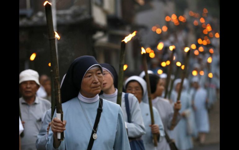 Un grupo de monjas sostiene antorchas durante una procesión en la Catedral Urakami, en Nagasaki. EFE /