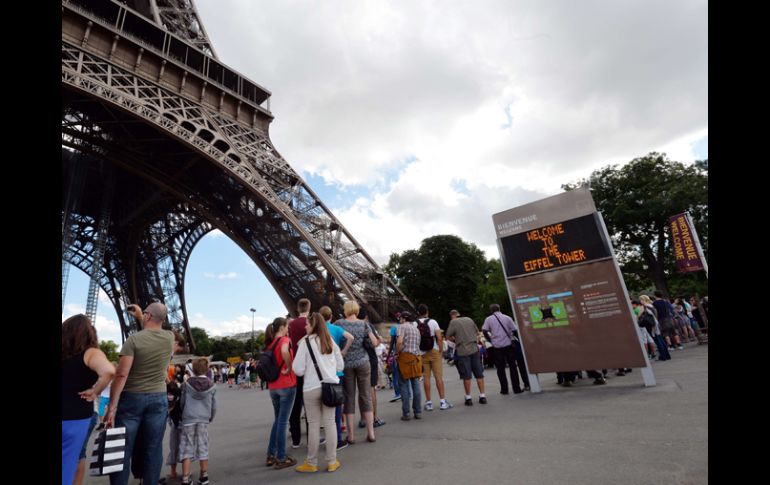 Turistas hacen fila para visitar la torre Eiffel tras su reapertura al público. AFP /