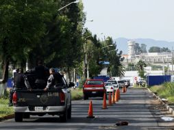 Policías resguardan las inmediaciones del penal de Puente Grande donde permanecía recluido Rafael Caro Quintero. AFP /