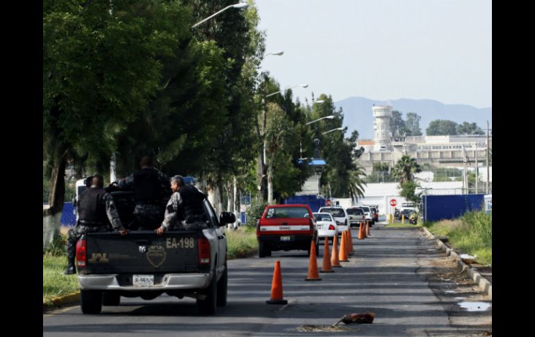 Policías resguardan las inmediaciones del penal de Puente Grande donde permanecía recluido Rafael Caro Quintero. AFP /