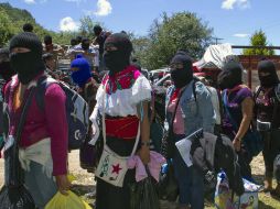 Con pasamontañas y sus trajes típicos, los zapatistas organizaron la salida de los alumnos. AFP /