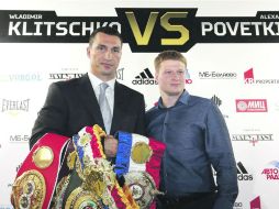 Wladimir Klitschko, campeón mundial del peso Pesado sostiene sus títulos junto al aspirante a la corona, el ruso Alexander Povetkin. EFE /