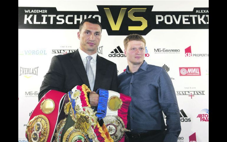 Wladimir Klitschko, campeón mundial del peso Pesado sostiene sus títulos junto al aspirante a la corona, el ruso Alexander Povetkin. EFE /