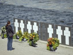 Una turista y frente a varias coronas de flores que han sido depositadas en un monumento levantado en recuerdo a las víctimas del Muro. EFE /