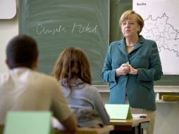 Ángela Merkel enseña a jóvenes de secundaria la hisoria del muro de Berlín. EFE /