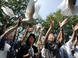 Mujeres sueltan palomas blancas como símbolo de paz, en la celebración del 68 aniversario del final de la Segunda Guerra Mundial. EFE /