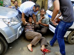 Varios manifestantes atienden a un hombre herido durante los choques. EFE /