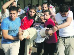 Partidarios de la Hermandad Musulmana cargan a un compañero herido cerca de la plaza Ramses, en El Cairo. AFP /