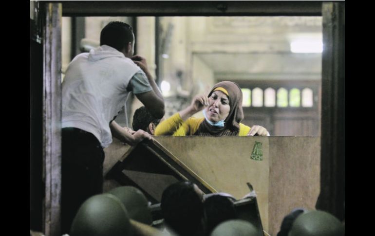 Una mujer habla con los policías desde el interior de la mezquita Al-Fatah, donde se encontraban los partidarios de Mohamed Morsi. AFP /