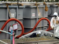 Un empleado de Tokyo Electric Power Company pasa cerca de tanques llenos de agua radioactiva en la central. EFE /