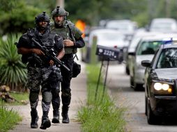 Oficiales de la policía SWAT corren hacia la Academia de Aprendizaje Ronald E. McNair. AP /