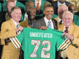 El ex mariscal Bob Griese (izq.) y el ex entrenador Don Shula (der.) le entregaron un jersey firmado a Barack Obama. AP /