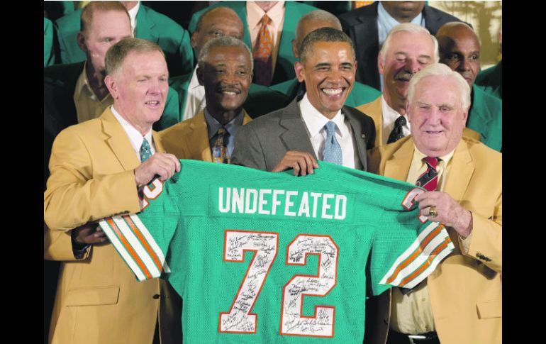 El ex mariscal Bob Griese (izq.) y el ex entrenador Don Shula (der.) le entregaron un jersey firmado a Barack Obama. AP /