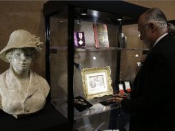 Brian Roughton, director de la casa de subastas, abre una vitrina donde se exhiben algunos objetos del pintor. AFP /