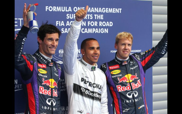 Lewis Hamilton (c) y Sebastian Vettel (d), calificado en el segundo puesto, junto a Mark Webber (i) al terminar la ronda. AFP /